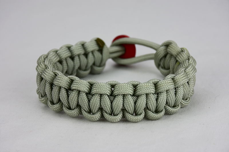 grey paracord bracelet with red button, picture of a grey paracord bracelet with red button fastener on a white background