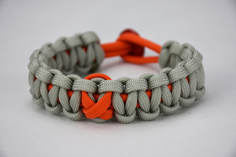 orange and grey leukemia support paracord bracelet with orange ribbon and red button, picture of a orange and grey paracord bracelet unity band with a orange ribbon in the center and red button fastener, leukemia support