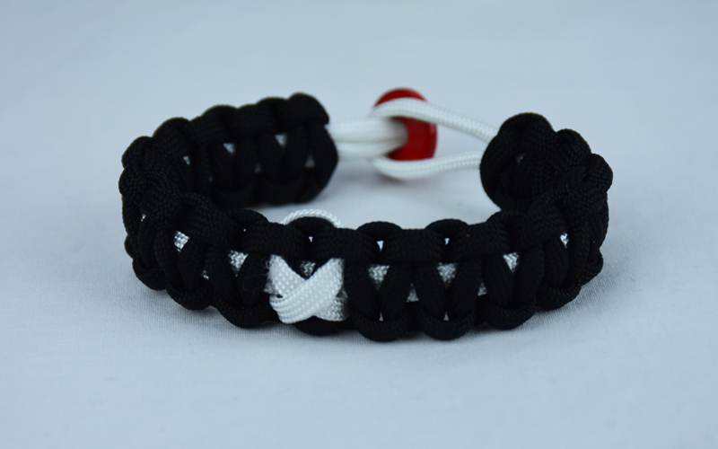 white and black multiple sclerosis support paracord bracelet with red button in back and white ribbon